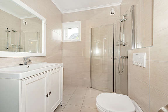 Nyoppusset bad i 1. etasje med dusjhjørne, vegghengt toalett og flott innredning Galleribilde