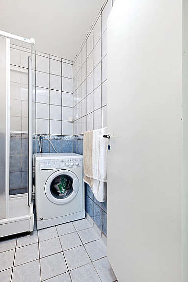 Flislagt bad med opplegg for vaskemaskin. Galleribilde