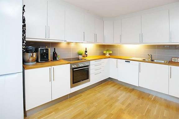 Kjøkken m/pen, hvit innredning fliser over benk. Integr. hvitevarer. Galleribilde