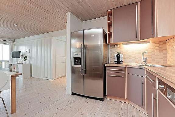 Kjøkkenet har takhøye skap, laminat benkeplate og delikate fliser. Galleribilde