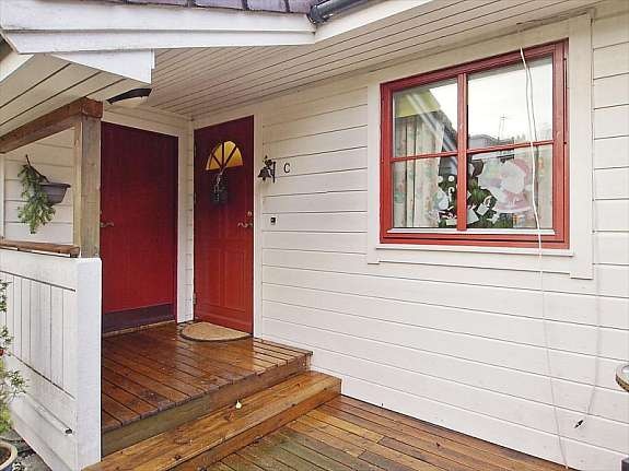 Overbygd inngangsparti og terrasse med formiddagssol. Galleribilde