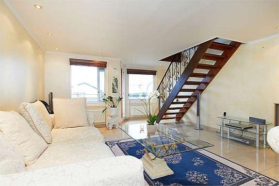 Stue med flott heltre trapp med smijernsrekkverk opp til andre etasje Galleribilde