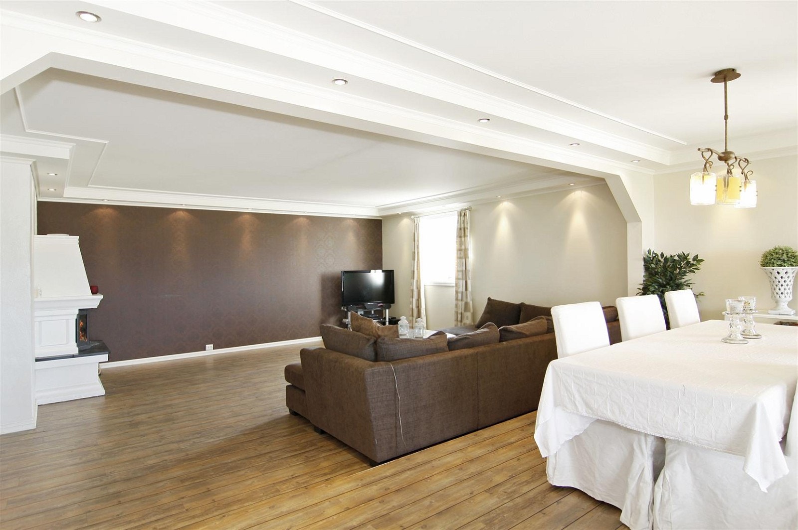 Fin belysning i stue fra downlights og store vinduer mot terrasse. Galleribilde