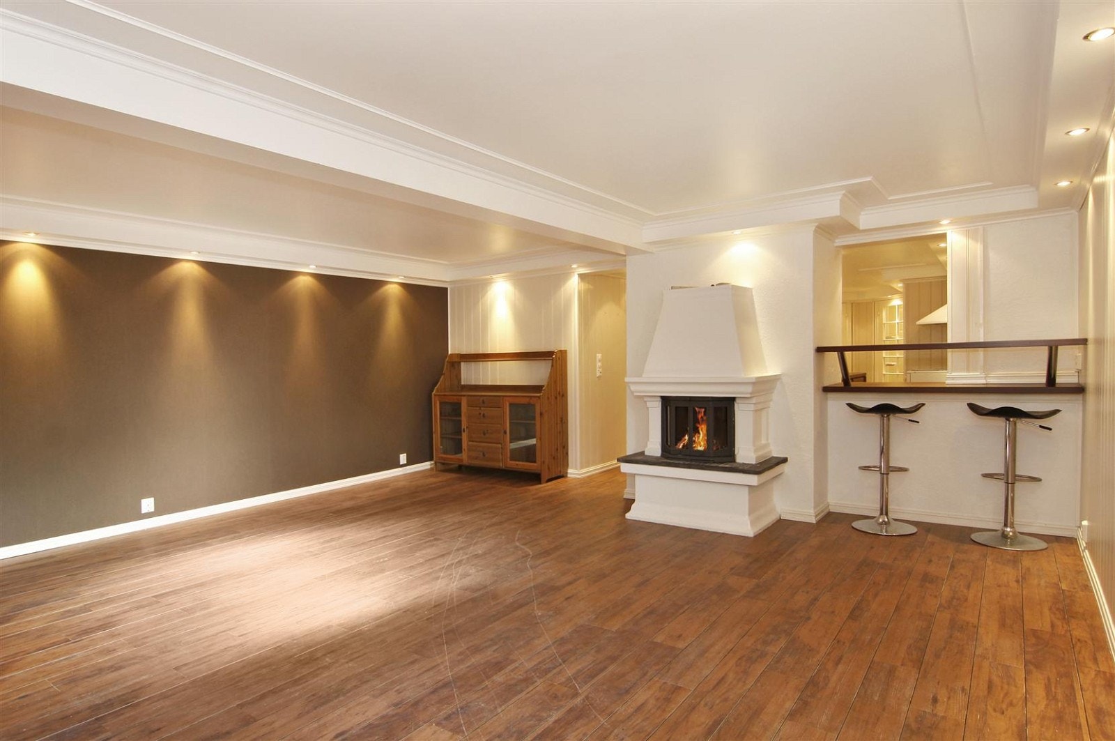 Stue i i kjeller med downlights og peis med innsats. Galleribilde