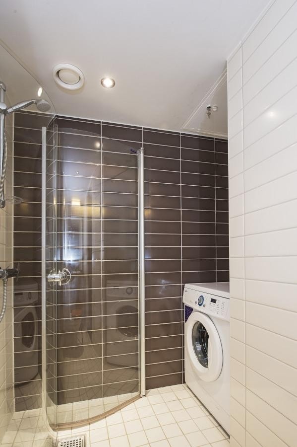 Badet har dusjhjørne og vaskemaskin Galleribilde