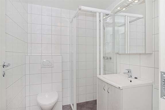 Dusjbad med baderomsinnredning og toalett. Galleribilde
