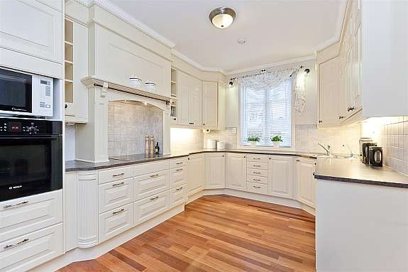 Lys fin kjøkkeninnredning som går til taket. Galleribilde