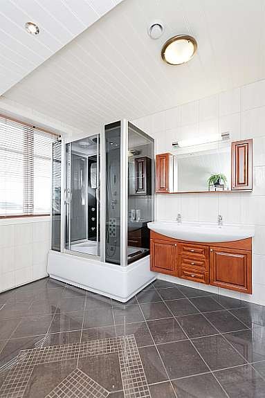 Flott stort bad med stort dusjkabinett servanter og innredning. Galleribilde