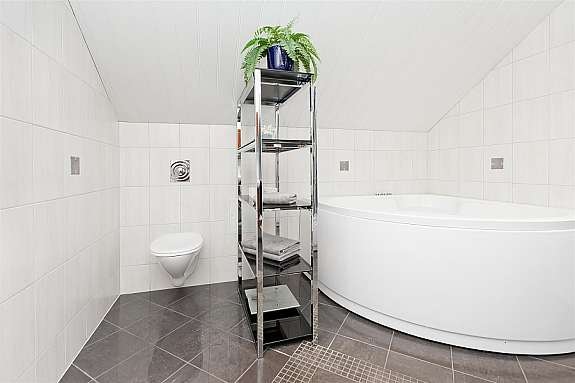 Vegghengt toalett og hjørnebadekar. Galleribilde