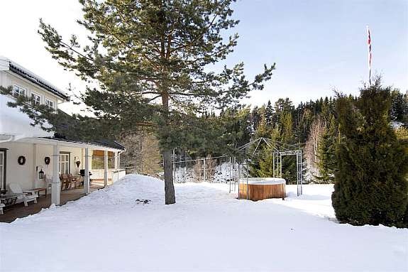 Hovedbygning med terrasse og massasjebad i hage. Galleribilde