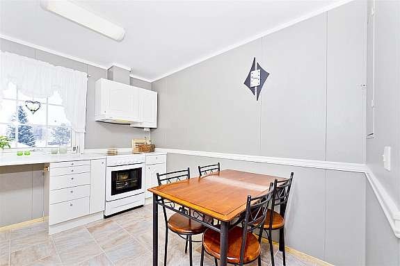 Lyst og pent kjøkken med spiseplass. Innredning i malt utførelse. Galleribilde