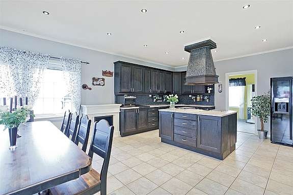 Stort kjøkken med beiset eik innredning fra Huseby. Kjøkkenøy med komfyr, grill og fritykoker. Stor spiseplass. Galleribilde