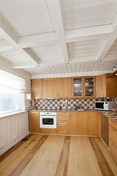 Romslig kjøkken med hyggelig spiseplass ved vinduet. Galleribilde