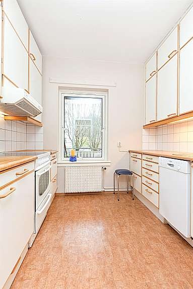 Kjøkkeninnredning fra ca 1990 med glatte innredning. Fliser over benk. Hyggelig utsyn til balkongen. Galleribilde