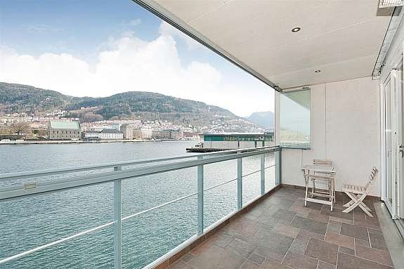 Bilde viser en av leilighetens to altaner. Her kan en nyte sjøluften og høre bølgeskvulpen slå mot bl.a. byggets brygge. Galleribilde