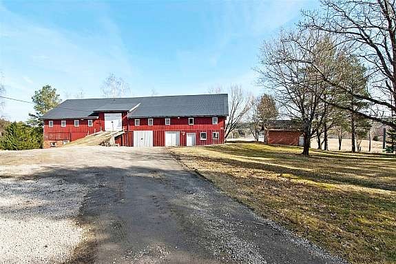 Stor låve og et uthus på eiendommen. Bildet er tatt ned mot Glomma. Galleribilde