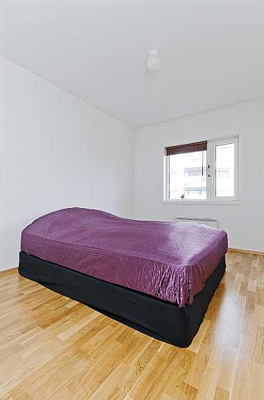 Romslig og praktisk soverom med god plass til dobbelseng, kommoder og en kontorpult. Galleribilde