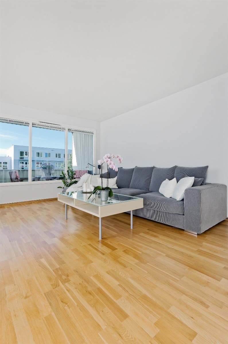 Fin stue med eikeparkett på gulv og malte lyse vegger. Galleribilde