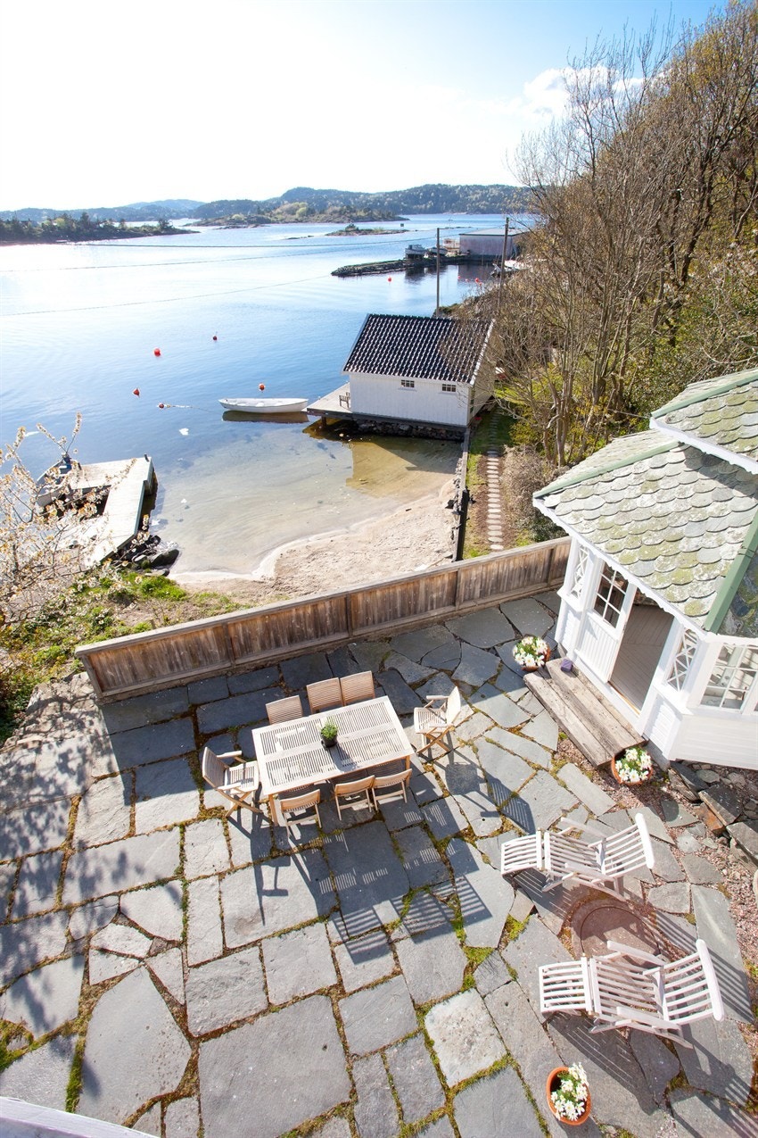 Oversiktsbilde med uteplass, lysthus og sjøbu Galleribilde