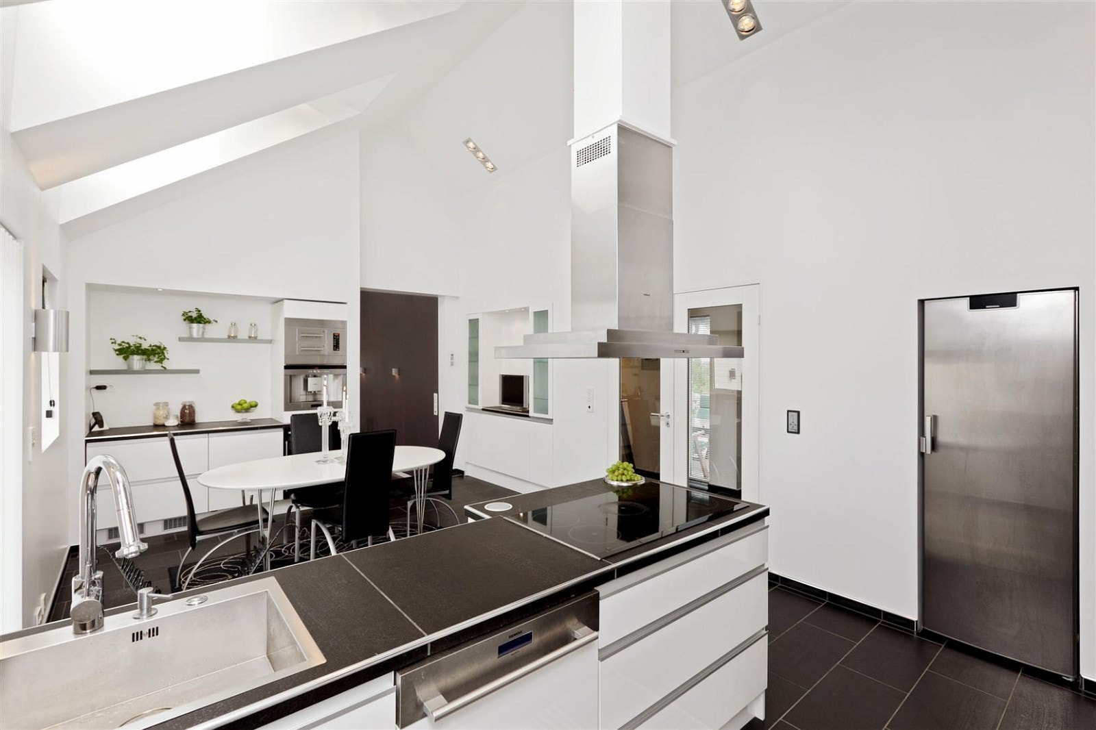 Tidsriktig Kvalsvik kjøkken med høyglans fronter, flislagte benkeflater, og egen spiseplass. Kjøkkenet har egen utgang til stor vestvendt terrasse med svært gode sol forhold. Galleribilde