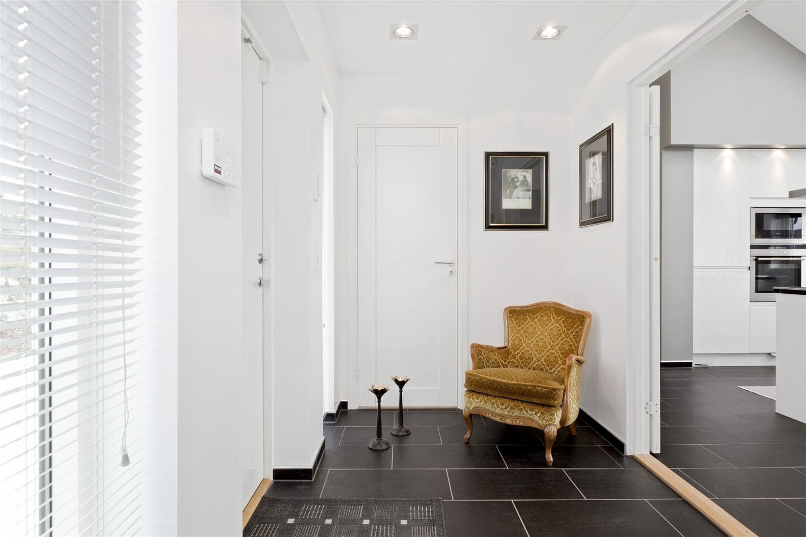 Innbydende hall med flislagt gulv, stor garderobe, innfelt safe i vegg, og ingang til teknisk skap. Galleribilde