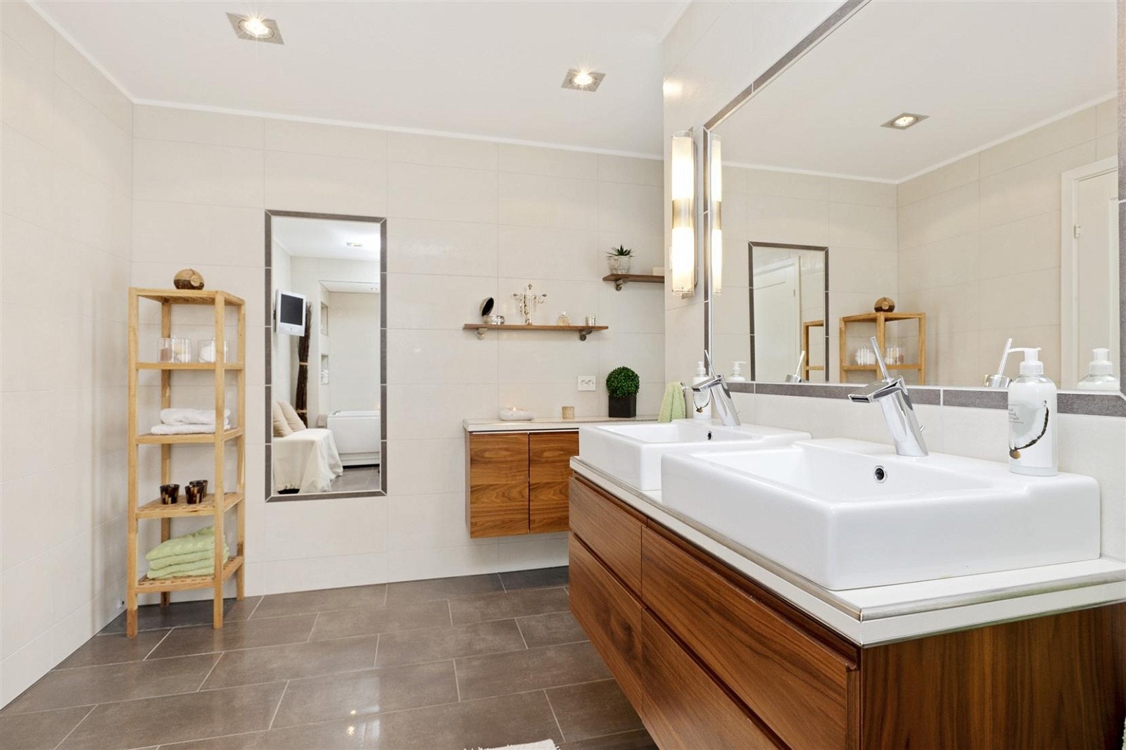 Flislagt og romslig bad som inngår som en del av "masterbedroom"-avdelingen. Kvalsvik innredning med god skapplass, delvis innmurt massasjebadekar med nisjebelysning, wc, vegg hengt TV, og egen dusjnisje med Rainshower-system fra Grohe. Galleribilde