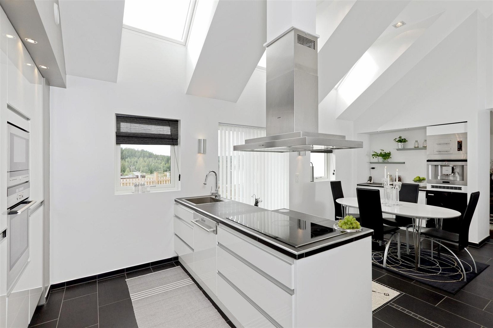 Tidsriktig Kvalsvik kjøkken med høyglans fronter, flislagte benkeflater, og egen spiseplass. Kjøkkenet har egen utgang til stor vestvendt terrasse med svært gode sol forhold. Galleribilde