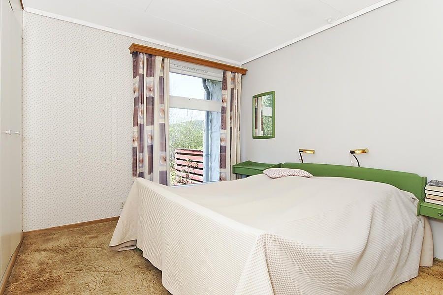 Soverom med god plass til seng og garderobeskap. Teppe på gulv. Galleribilde