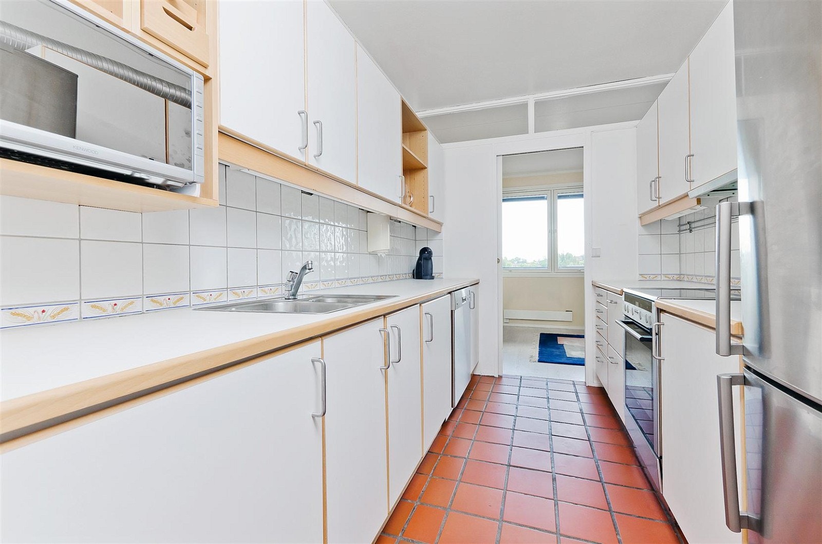 Kjøkkeninnredning med fronter i laminat og bøkeomramming. Galleribilde