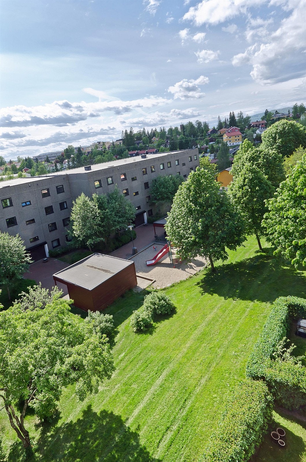 Utsikt fra verandaen mot borettslagets grønne fellesområder. Galleribilde