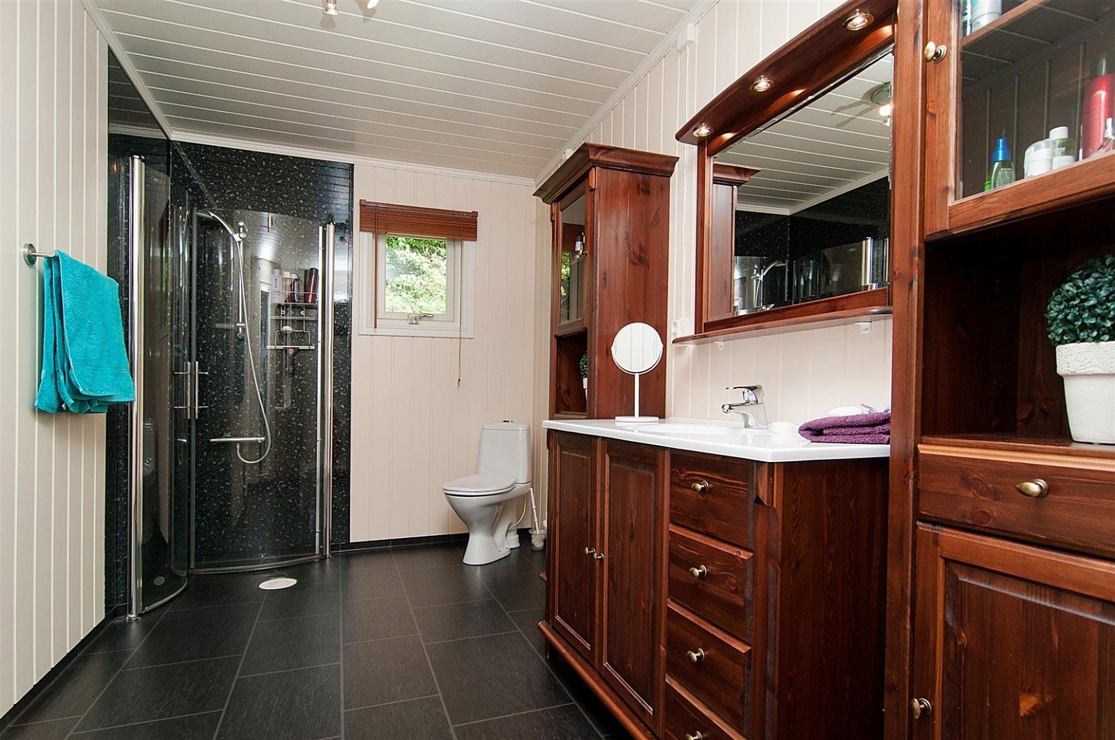 Pent bad/wc i 1 etg., modernisert i 2007. Heltre innredning med mørke fronter og servantplate, speil med spotbelysning over servanten. Vegger i dusjsone har laminat våtromsplater. Galleribilde