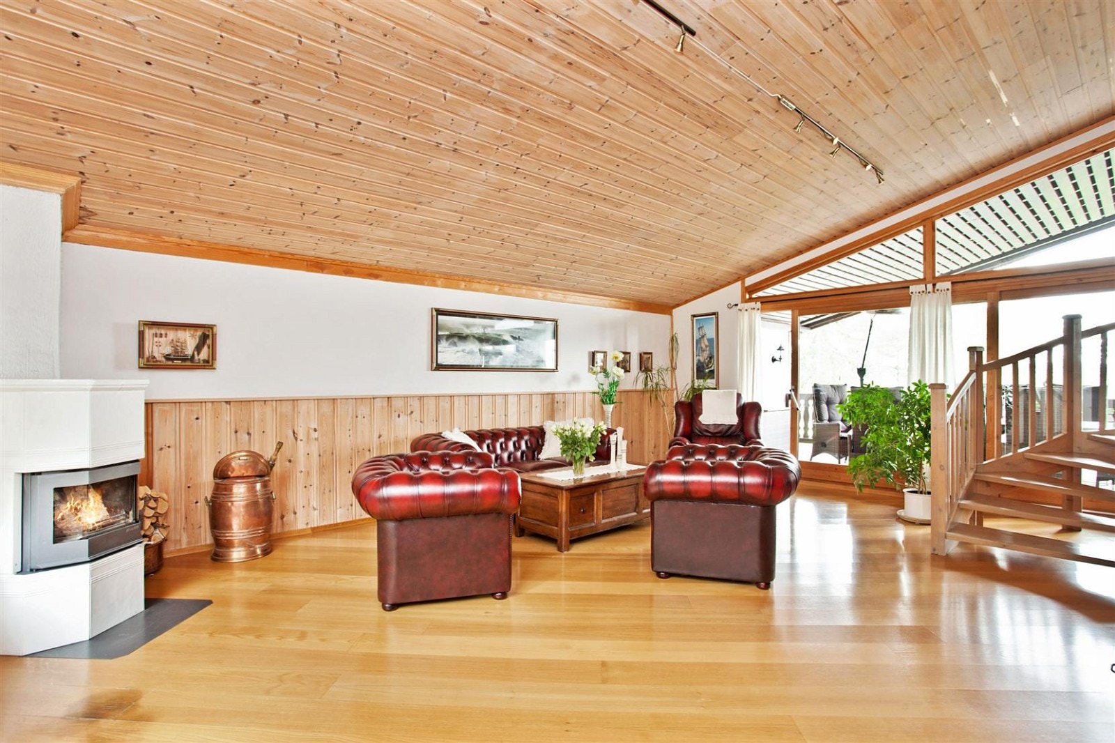 Romslig tv-stue med bl.a. peis og utgang til terrasse Galleribilde
