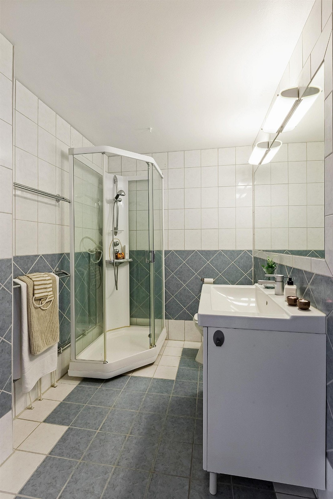 Flislagt og romslig bad med dusjkabinett og varmekabler på gulv. Galleribilde