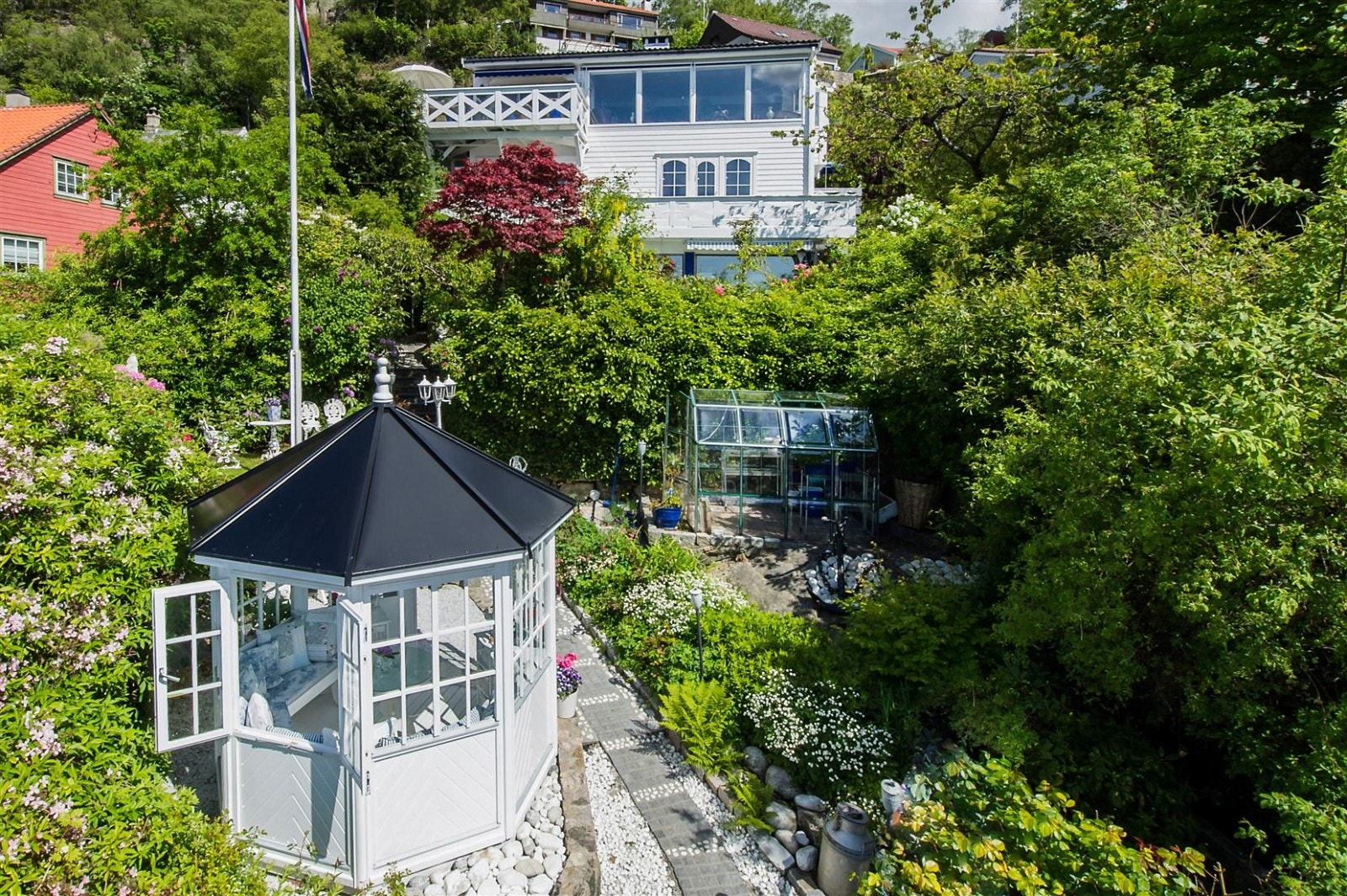 Front av huset med lysthus i forgrunnen. Galleribilde