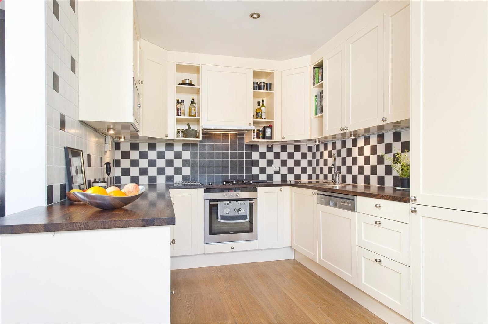 Lyst og pent kjøkken med integrerte hvitevarer.
2 induksjon og 2 gassbluss på komfyren. Galleribilde