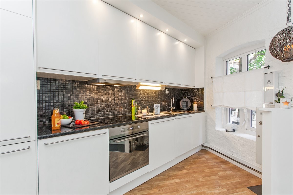 Moderne og stilrent kjøkken med integrerte hvitevarer Galleribilde