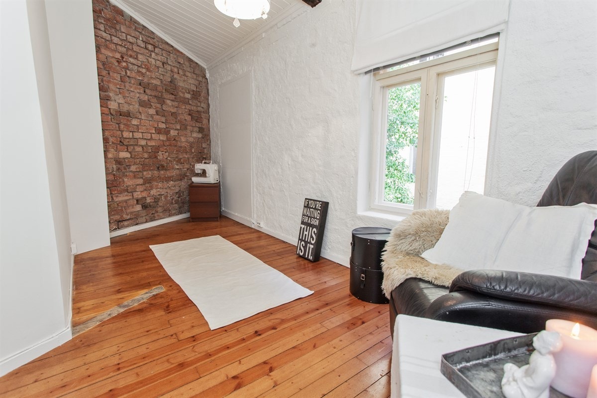 Soverom 2. Her er det hentet frem original teglstein på den ene veggen som skaper en flott kontrast i rommet. Eier har fått godkjent fra sameiet bygging av balkong på dette rommet. Galleribilde