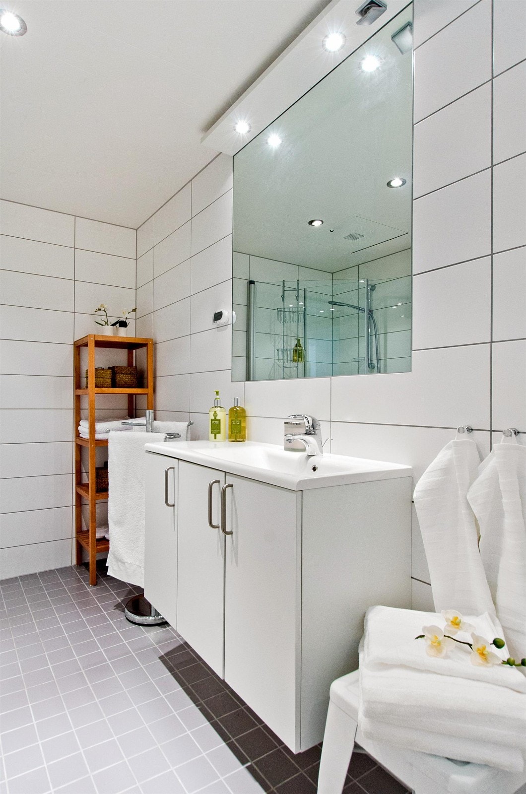 Pent flislagt bad med heldekkende servant med underskap og veggehengt toalett. Galleribilde