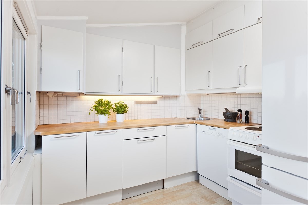 Kjøkkenet er tilpasset planløsningen med god benkplass og takhøye skap. Komfyr og oppvaskmaskin følger med leiligheten. Oppvaskmaskinen er Miele og kjøpt ny i 2013. Galleribilde
