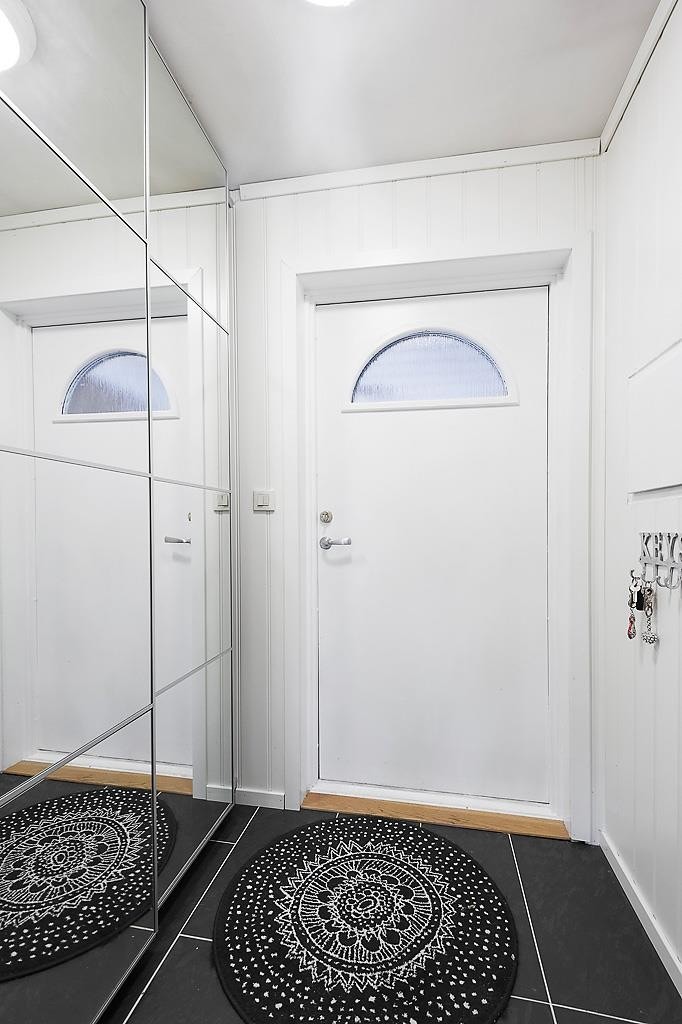 Smart entré med garderobe og fliser på gulv Galleribilde