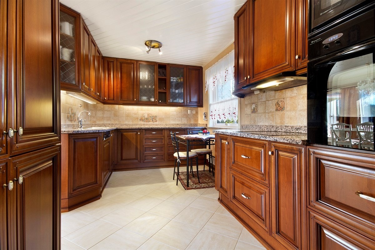 Flott heltre kjøkken med larvikitt benkeplate og gode integrerte hvitevarer Galleribilde