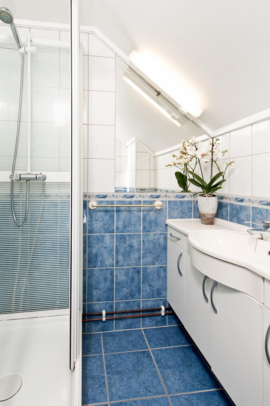 Badet er flislagt og har varmekabler i gulvet. Det består av servant m/underskap, dusjkabinett m/herdet glass og toalett. Galleribilde