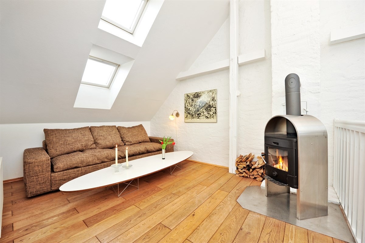 Loftstue med vedovn og sittegruppe. Galleribilde