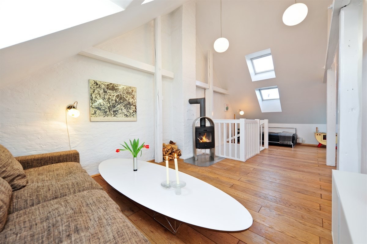 Loftstue med sittegruppe og vedovn. Galleribilde