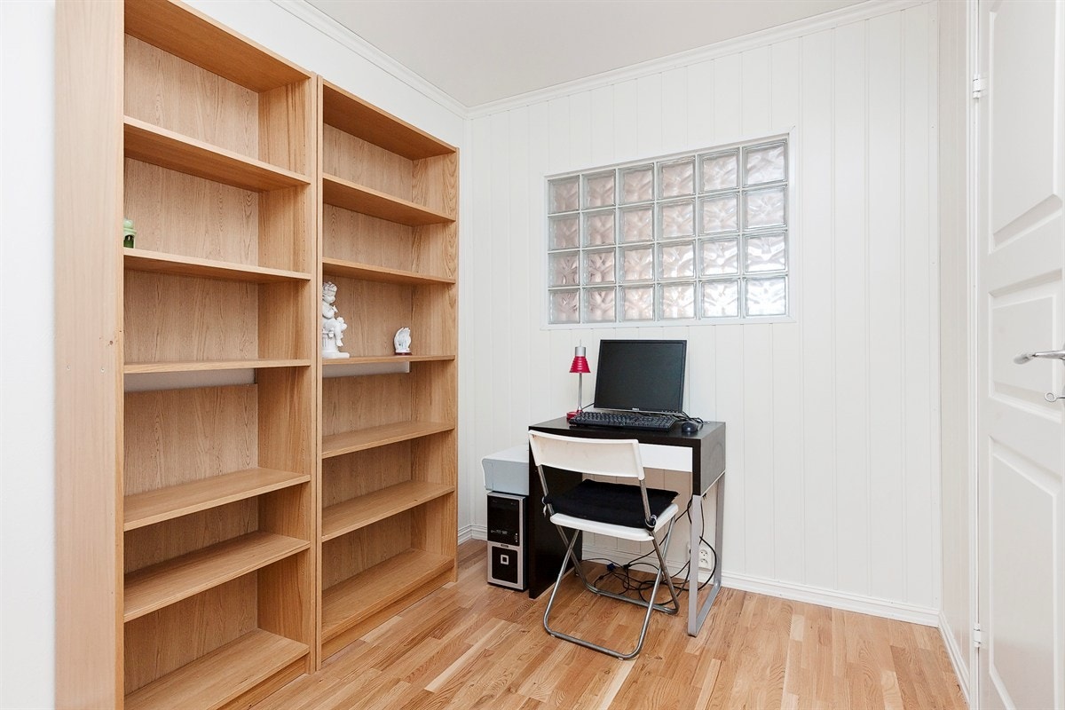 Kontor. Et vindu av glassbyggersten sørger for dagslys inn i rommmet Galleribilde