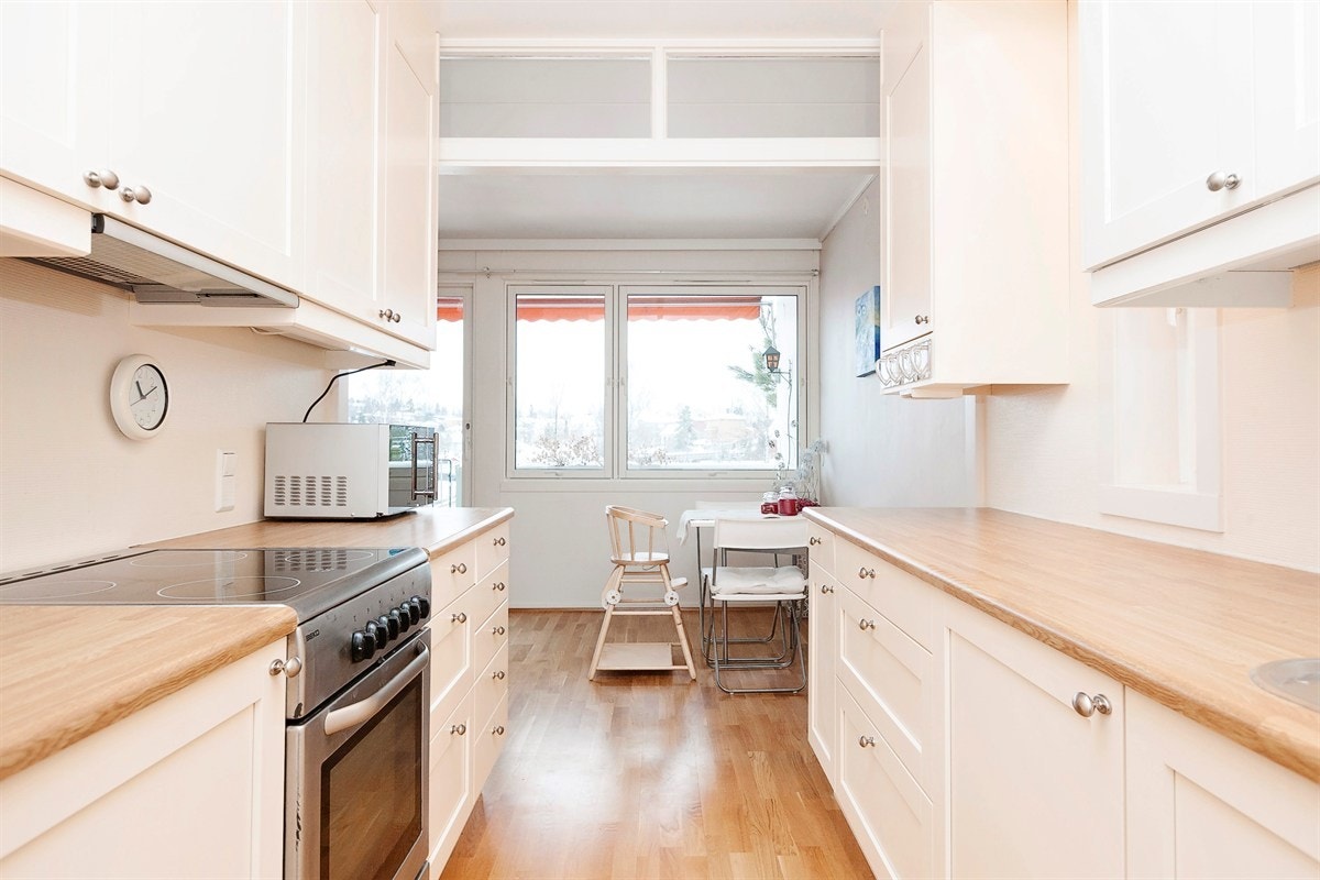 Lyst og funksjonelt kjøkken med takhøye overskap Galleribilde