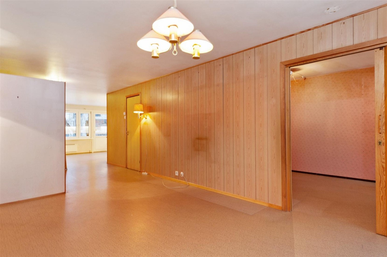 Fra venstre ser man kjøkken, så dør til bad, deretter skyvedør til et av soverommene. Galleribilde