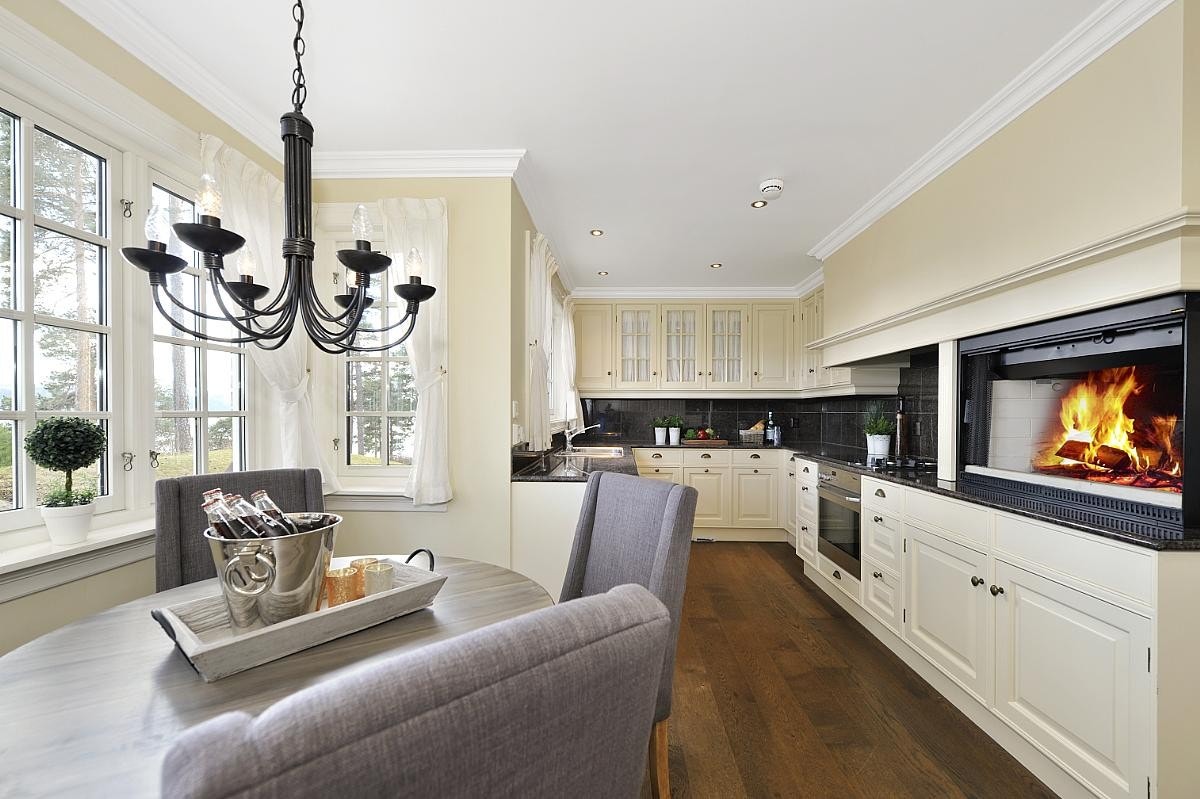 Delikat og romslig spisekjøkken med peis Galleribilde