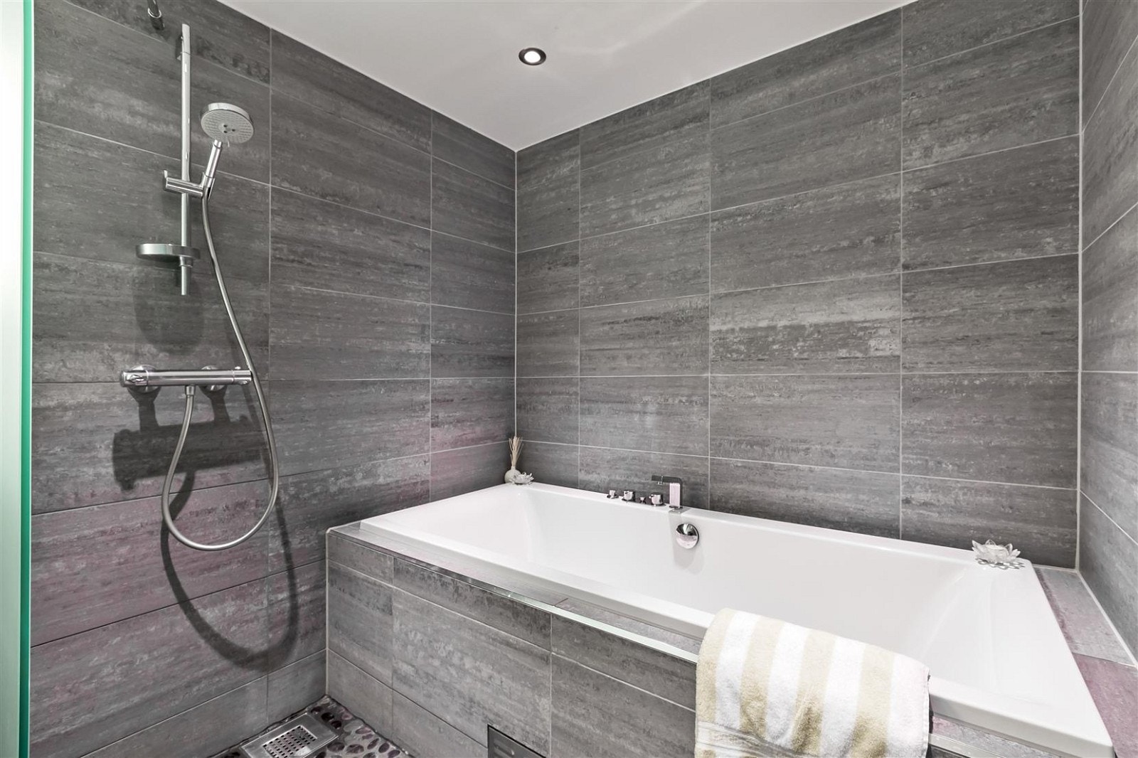 Badet har bla. innkledd badekar, dusjnisje, vegghengt WC, varmekabler, downlights og opplegg for vaskemaskin Galleribilde