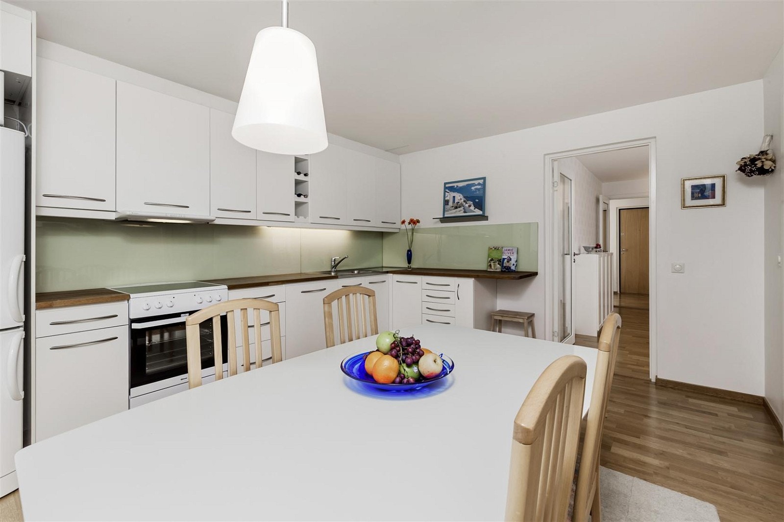 Innholdsrikt kjøkken med bl.a. benkeplate i eik, vinhylle og avtrekksvifte Galleribilde